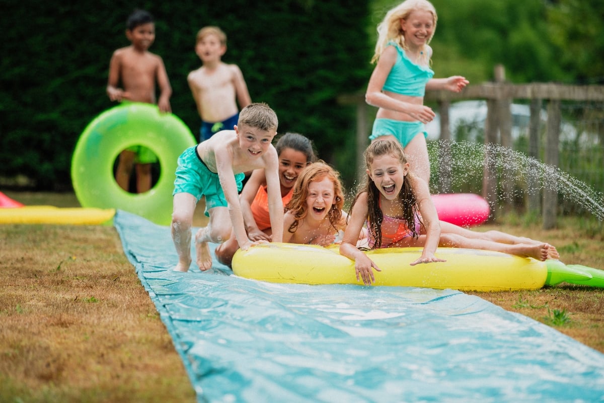 kids playing with water toys in backyard during summer