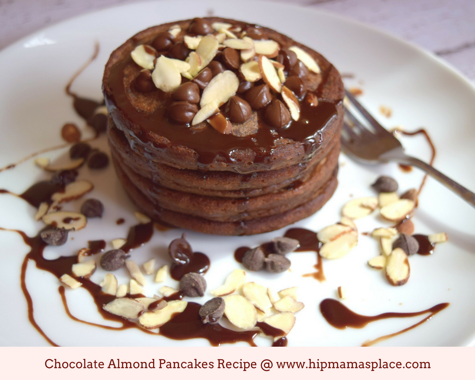 a photo of chocolate almond pancakes stack drizzled with chocolate syrup 