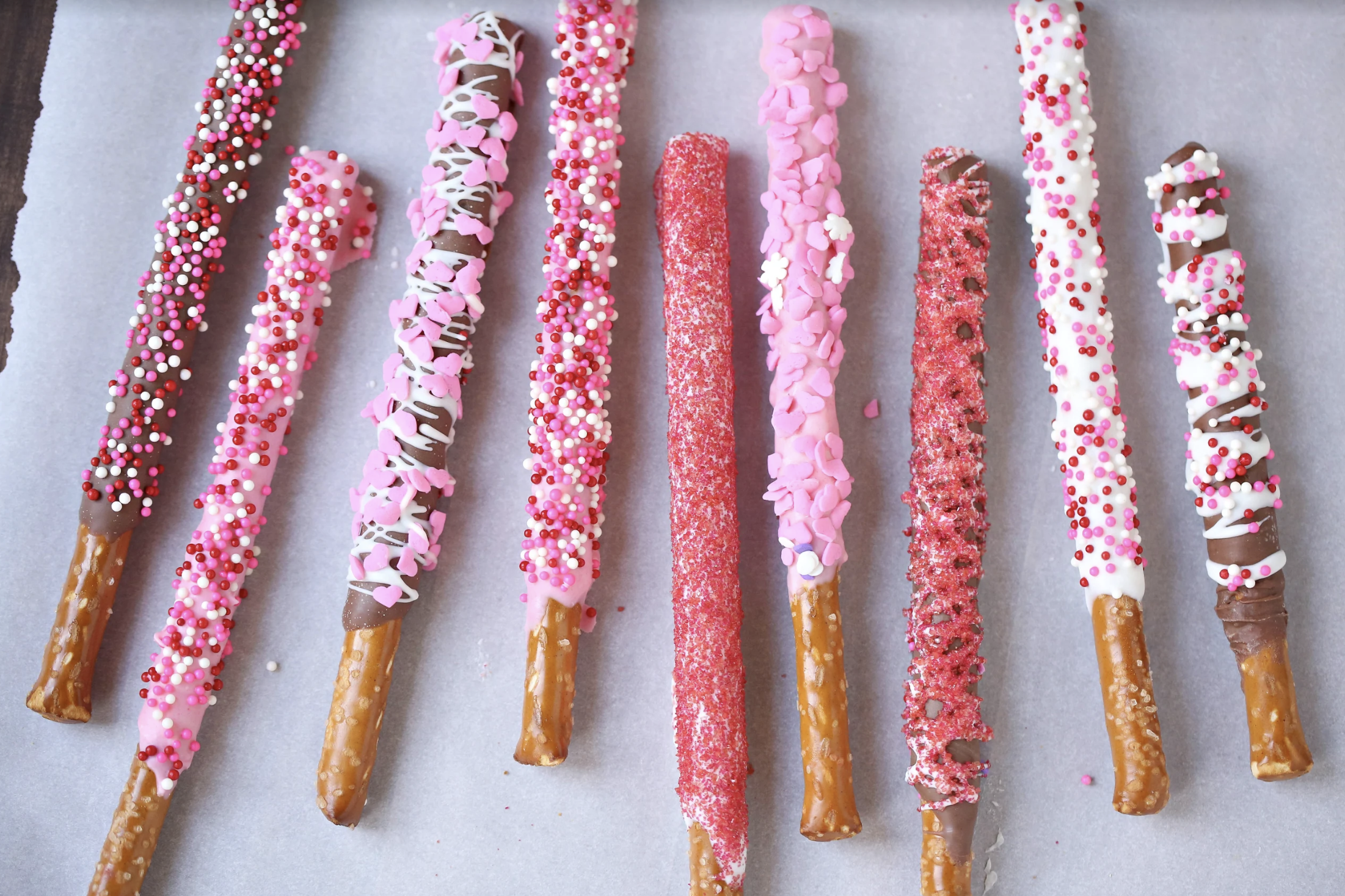 chocolate covered pretzels with pink and red sprinkles 