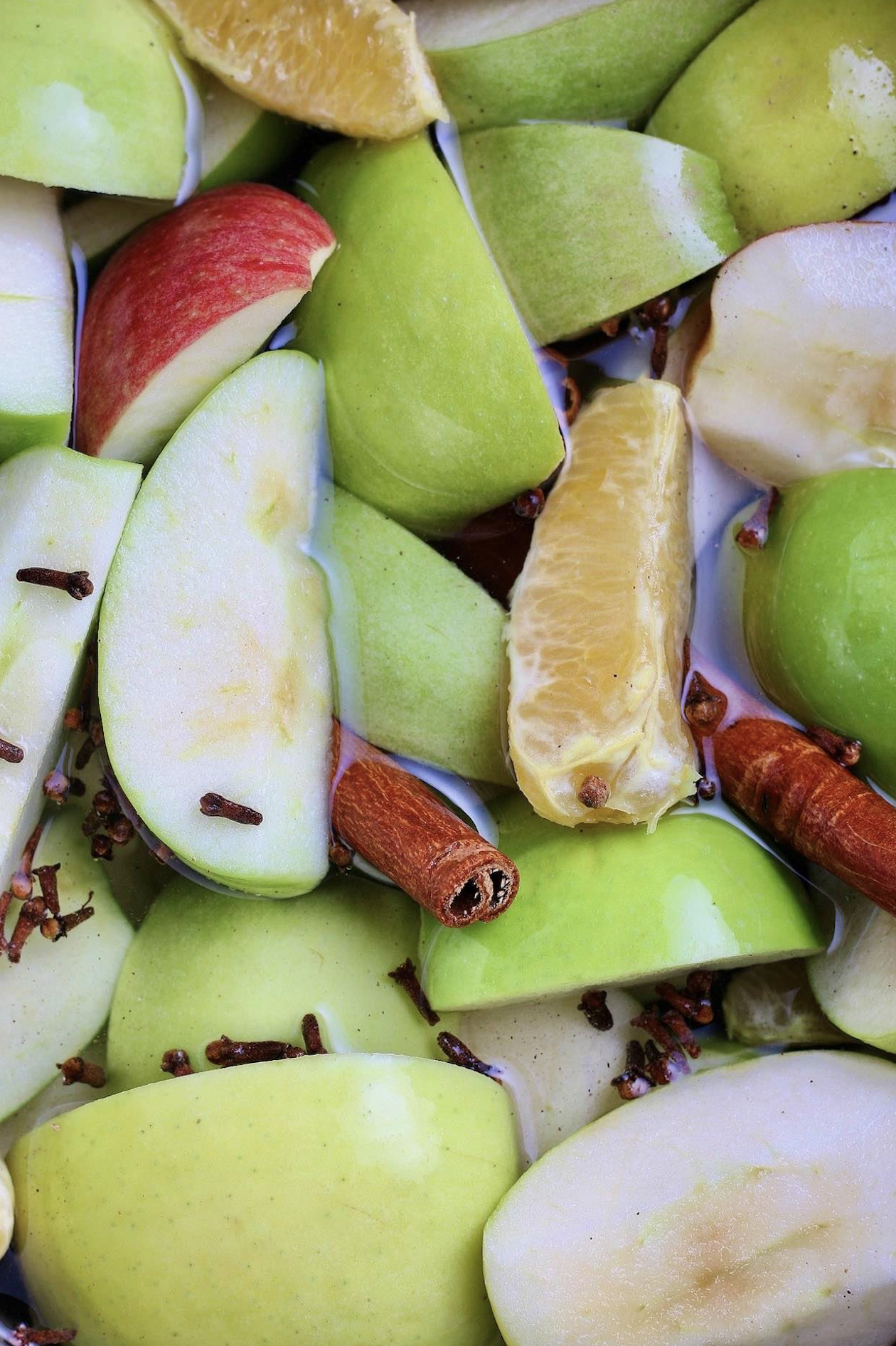 Apples, oranges, and spices simmering in water. 