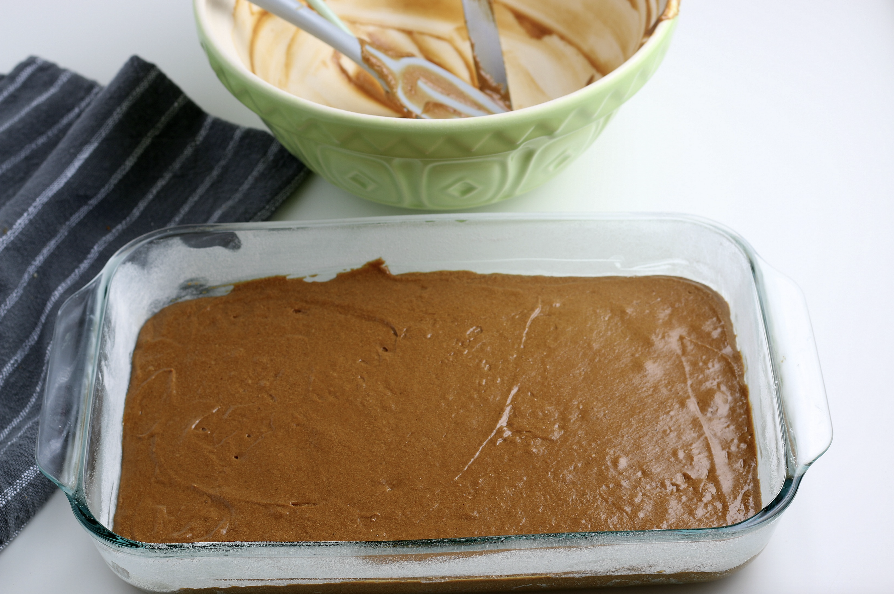 Spreading the cake batter into a casserole dish. 