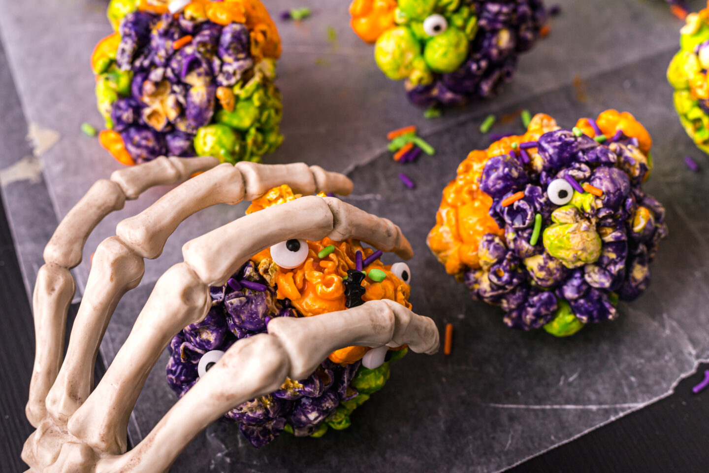 A plastic skeleton hand reaching out to grab the Halloween salty treats 