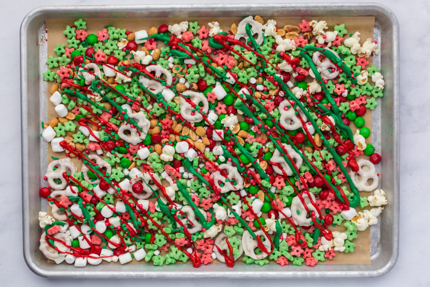 red and green candy melts drizzled over Elf on the Shelf Mischief Munch with sprinkles 