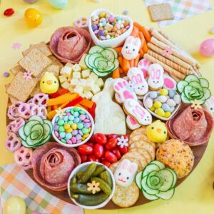 Easter snack board with candy, cheese, vegetables, crackers, and festive bunny treats