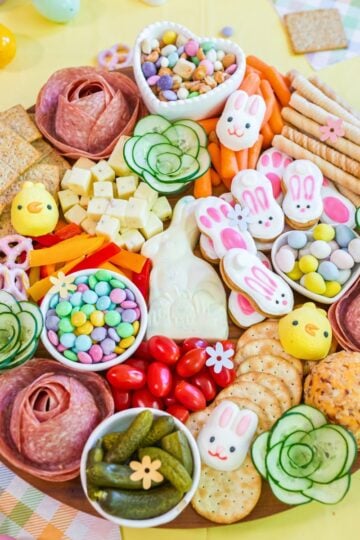 Easter snack board with candy, cheese, vegetables, crackers, and festive bunny treats