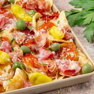 charcuterie nachos with brie prosciutto olives and hot honey drizzle