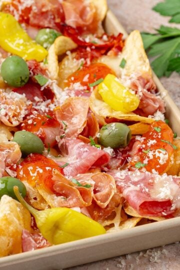 charcuterie nachos with brie prosciutto olives and hot honey drizzle