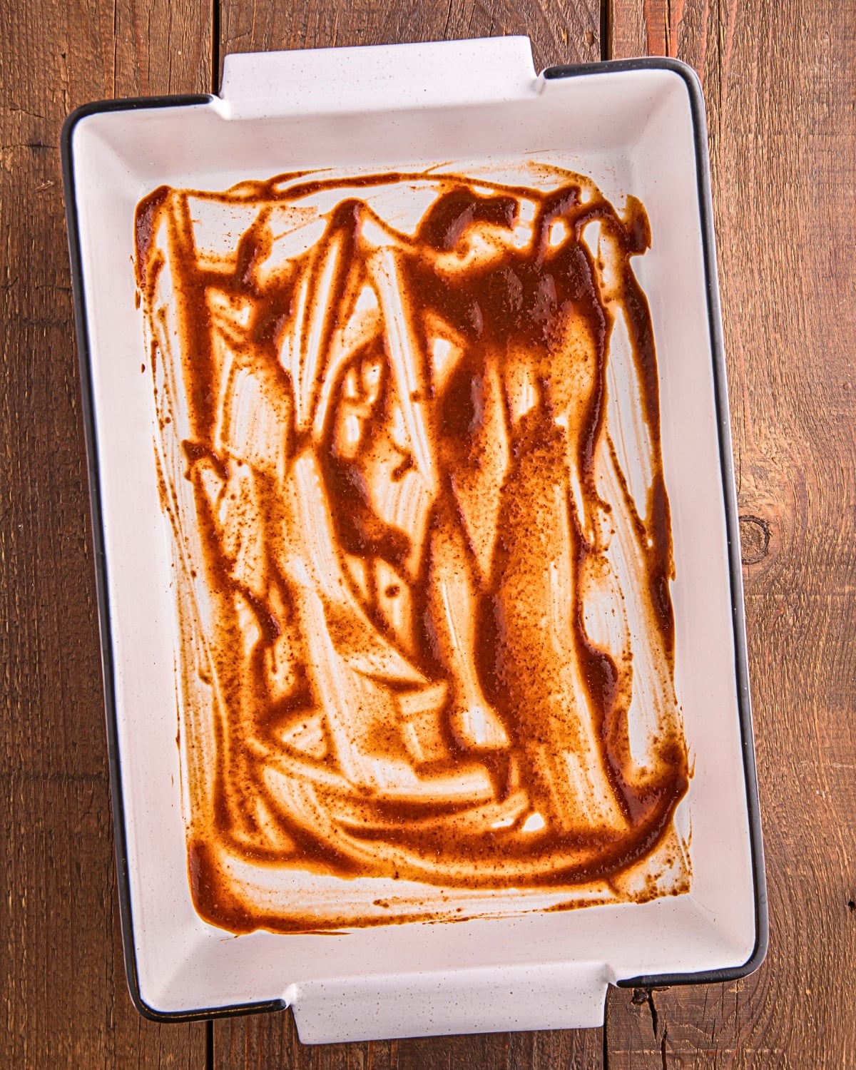 enchilada sauce on the bottom of baking dish for Mexican casserole