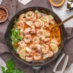 garlic butter sauce in skillet topped with with fresh lemon and parsley