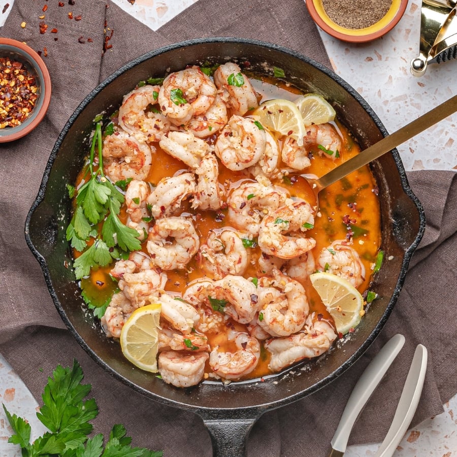 garlic butter sauce in skillet topped with with fresh lemon and parsley