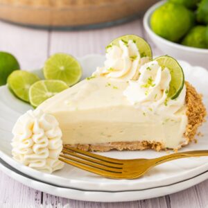 No-bake key lime pie with creamy lime filling, graham cracker crust, whipped cream topping, and fresh lime slices