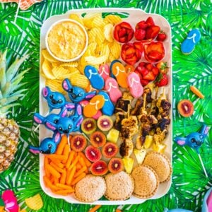 Lilo and Stitch snack board with tropical fruits, blue themed treats, popcorn, candy, and fun movie night snacks arranged for a family movie night