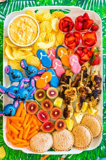 Lilo and Stitch snack board with tropical fruits, blue themed treats, popcorn, candy, and fun movie night snacks arranged for a family movie night
