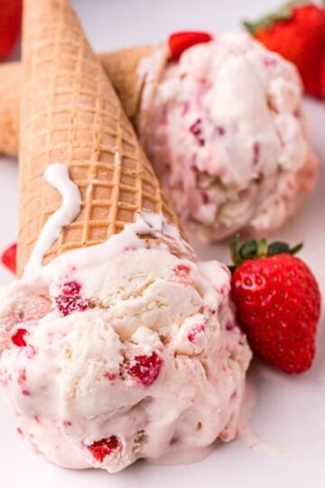 No churn strawberry ice cream in a loaf pan topped with fresh strawberries, creamy homemade strawberry ice cream without an ice cream maker