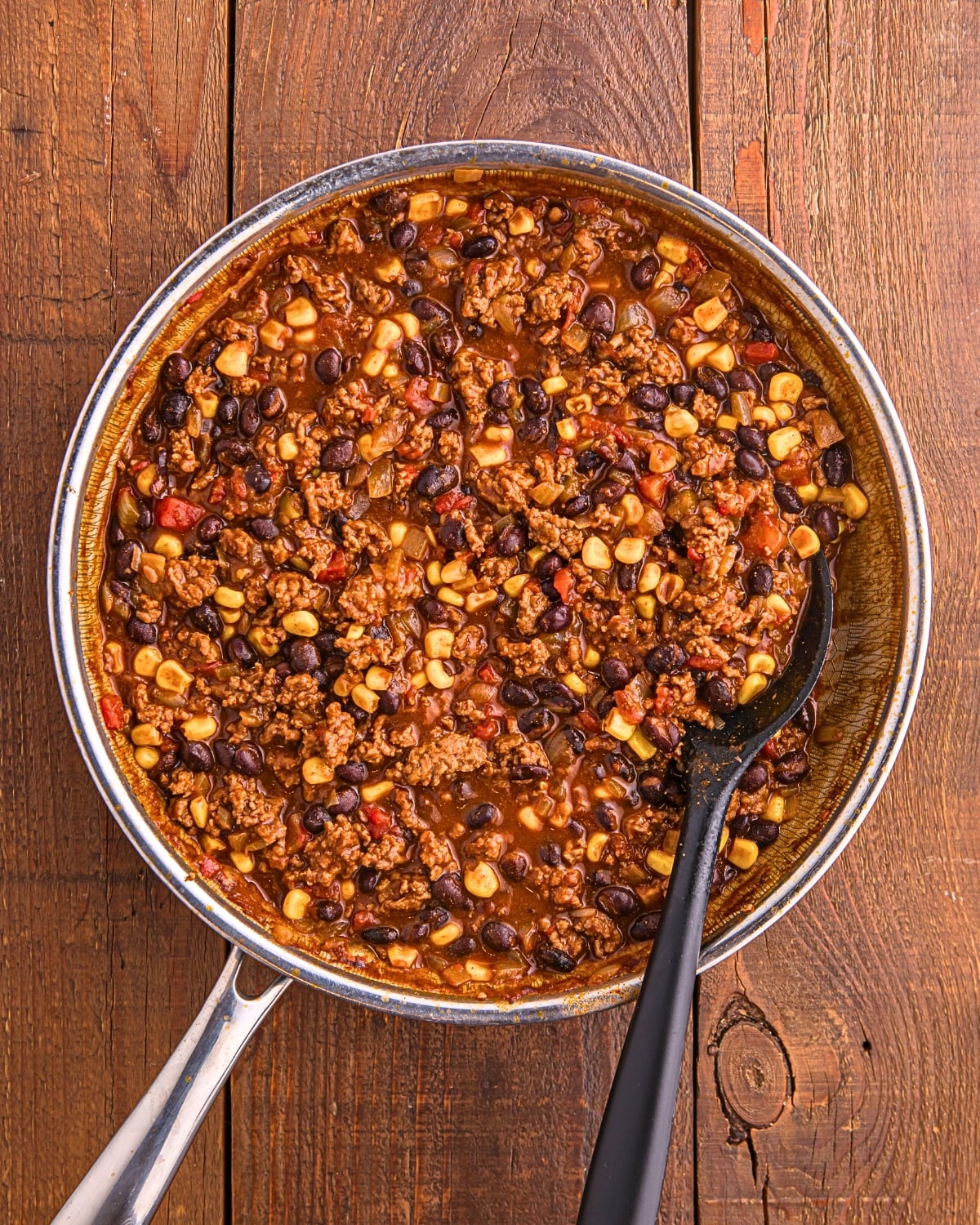 thick taco beef mixture with beans corn and tomatoes for mexican casserole