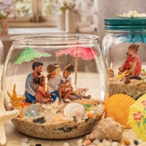 DIY beach memory jar with sand, seashells, photos, and coastal keepsakes in a mason jar for summer beach decor