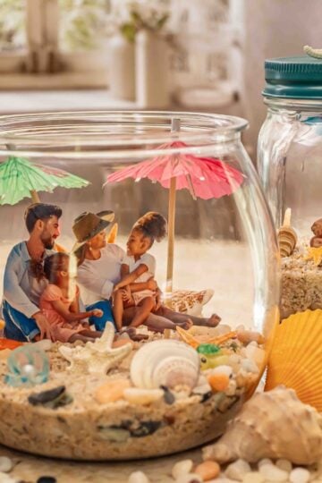 DIY beach memory jar with sand, seashells, photos, and coastal keepsakes in a mason jar for summer beach decor