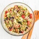 Healthy Greek Quinoa Salad with roasted vegetables, chickpeas, feta cheese, olives, tomatoes, and fresh herbs in a large serving bowl.