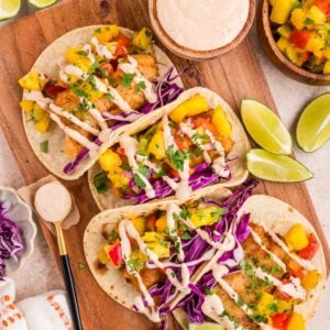 Beer battered fish tacos with mango salsa, purple cabbage and creamy chipotle sauce