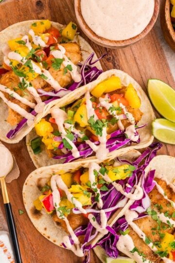 Beer battered fish tacos with mango salsa, purple cabbage and creamy chipotle sauce