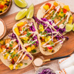 Crispy beer battered cod tacos topped with fresh mango salsa, purple cabbage, and creamy chipotle sauce.