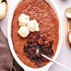 Warm Ina Garten brownie pudding with a crackly chocolate top and gooey center served with vanilla ice cream