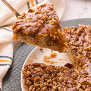 Pecan upside down cake with a glossy brown sugar pecan topping on a serving plate.
