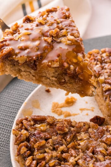 Pecan upside down cake with a glossy brown sugar pecan topping on a serving plate.
